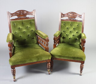 A pair of late Victorian carved oak open arm chairs upholstered in green buttoned Dralon with bobbin turned decoration, raised on turned supports  