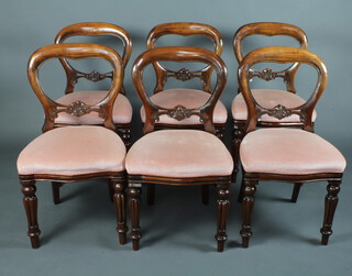 A set of 6 Victorian style mahogany balloon back dining chairs with pierced mid rails and over stuffed seats, raised on turned and fluted supports 