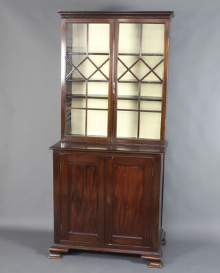 A 19th Century mahogany display cabinet on cabinet, the upper section with moulded cornice, fitted adjustable shelves enclosed by astragal glazed panelled doors, the base fitted a cupboard enclosed by panelled doors and raised on bracket feet 186cm x 85cm x 49cm 