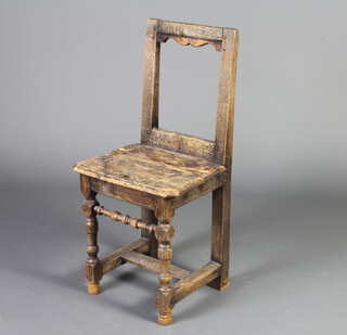 A 17th/18th Century bleached oak bar back hall chair with solid seat, raised on turned and block supports 