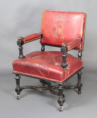A Victorian ebonised open arm chair, the red leather seat with earl's coronet and monogrammed R, raised on turned and block supports 