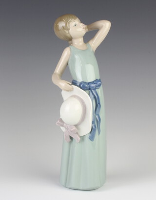 A Lladro figure of a girl holding her hat 5010 25cm 