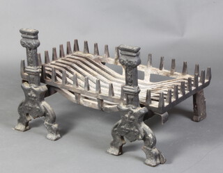 A pair of 19th Century iron fire dogs 48cm x 24cm x 50cm together with an associated basket 15cm x 75cm x 40cm 