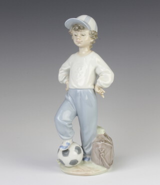 A Lladro Rotary International figure of a young boy with his football and kit bag 21cm  