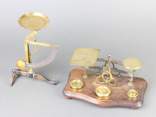 A pair of Continental polished brass and steel postal scales marked Ges.. Gesch together with 1 other pair raised on an oak base and complete with weights  