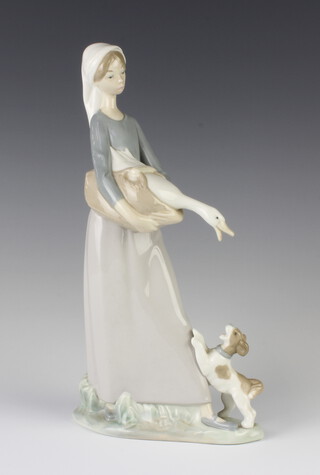 A Lladro figure of a girl holding a goose with a puppy at her feet 4866, 29cm 