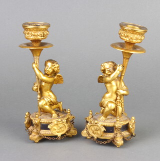 A pair of 19th/20th Century gilt ormolu candlesticks supported by figures of cherubs 18cm h  