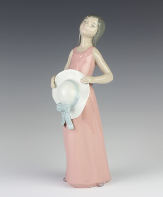 A Lladro figure of a girl holding a hat in front of her no.5088 26cm 