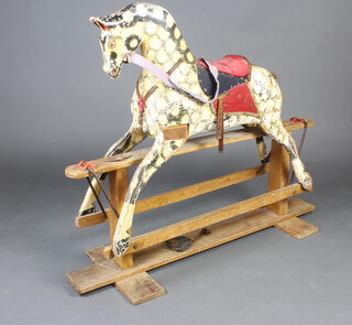 A dapple grey rocking horse on a beech stand 109cm h x 134cm w x 34cm d 