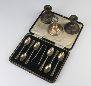 A set of 6 silver coffee spoons and sugar tongs London 1919, 82 grams cased and 3 dwarf silver candlesticks 