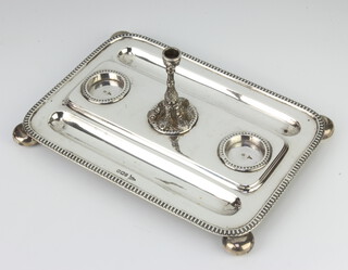 A Victorian rounded rectangular silver 3 division ink stand with pen trays, raised on ball feet with miniature cast candlestick, Sheffield 1898, maker Walker and Hall, 25cm, 622 grams 