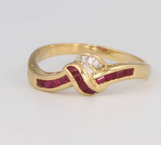 An 18ct yellow gold ruby and diamond crossover ring, size T 1/2, 3.9 grams 