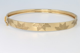 A 9ct yellow gold leaf engraved bangle 6.5 grams
