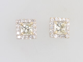 A pair of 18ct white gold diamond ear studs, the centre set with a princess cut diamond, each approx. 0.3ct surrounded by brilliant cut diamonds approx. 0.15ct each, total carat weight 1ct