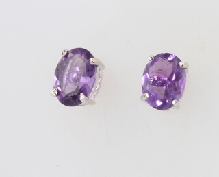 A pair of silver and amethyst ear studs