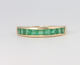 A 9ct yellow gold Princess cut emerald half eternity ring size O 1/2, 2.6 grams