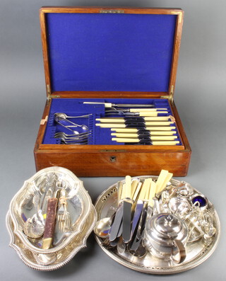 An Edwardian oak canteen containing a part canteen of plated cutlery and minor plated wares 