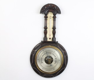 Aitchison London and Provinces, an Edwardian aneroid barometer and thermometer with silver dial contained in a carved oak case
