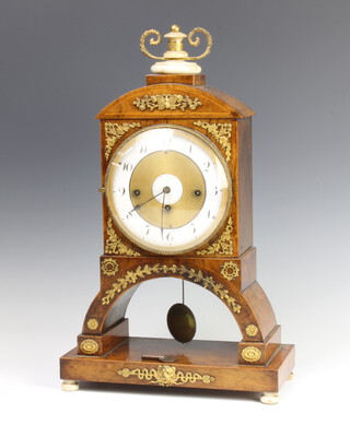 An 18th Century French 8 day striking mantel clock with silk suspension, striking on 2 gongs, having a gilt and enamelled dial with Roman numerals, contained in an arched inlaid walnut case with gilt metal mounts and turned ivory supports 