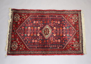 A red and blue ground Persian rug with diamond shaped central medallion 99cm x 60cm
