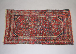 A Persian blue and green ground rug with 3 stylised medallions to the centre within a multi row border 120cm x 65cm 