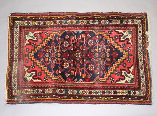 A Persian blue and red ground rug with central medallion 119cm x 78cm 