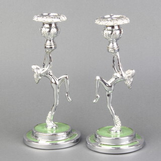 A pair of Art Deco chrome and enamel finished candlesticks in the form of dancing girls, raised on circular bases 21cm h x 9cm 