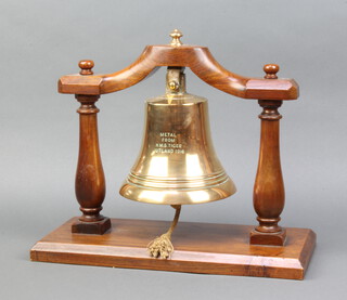 A brass table bell raised on a turned mahogany stand, bell marked "Metal from HMS Tiger Jutland 1916" 35cm h x 40cm w x 18cm d 