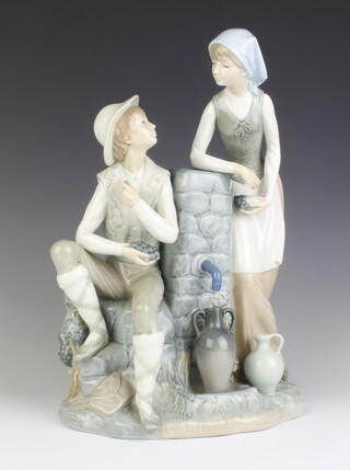 A large Nao figure group of a couple beside a water pump 34cm 