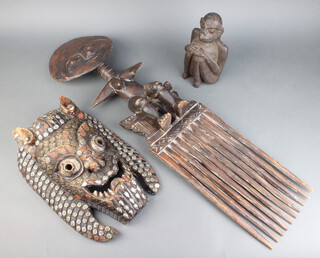 An Ashanti carved wooden fertility figure of a lady, the base incorporating a 10 spoked comb 89cm h x 24cm w, a carved wooden figure of a monkey 22cm x 11cm x 13cm and a carved and studded mask 38cm x 26cm 