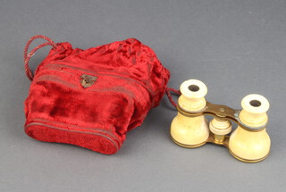 A pair of 19th Century gilt metal and ivory opera glasses contained in a plush red material bag 