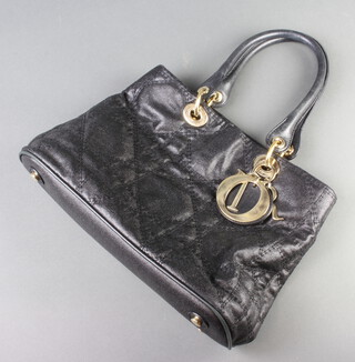 Christian Dior, a black quilted fabric handbag, having a black interior labelled Christian Dior, Paris, Made in Italy and numbered 09-BO-1009 to the reverse, having gilt embellishments and Dior letters,  23cm x 32cm x 11cm 