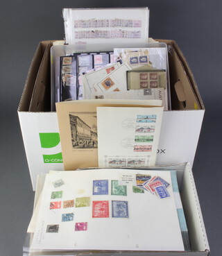 A quantity of album leaves with world stamps all contained in a bank box 