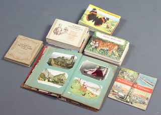 An album of coloured postcards and a collection of cigarette and tea cards