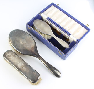 A cased silver hairbrush and comb Birmingham 1958, an engine turned hairbrush and clothes brush 
