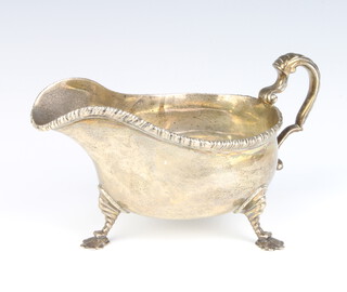 A silver sauce boat of Georgian design with S scroll handle, raised on scroll feet 442 grams, London 1912