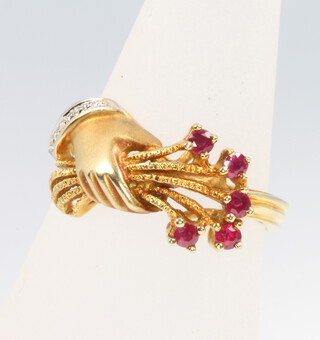 A 14ct yellow gold ruby and diamond ring with a hand holding a bunch of flowers, size N, 4.6 grams 