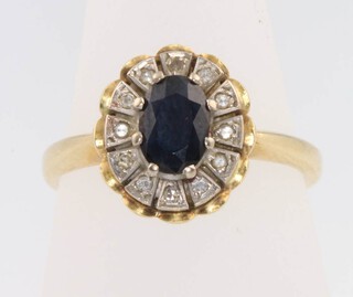 An 18ct yellow gold oval sapphire and diamond cluster ring size P