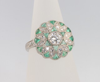 A platinum Edwardian style diamond and emerald cluster ring the centre stone approx 0.5ct size M 1/2