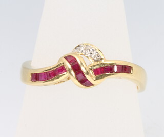 An 18ct yellow gold ruby and diamond cross over ring, size T 1/2, 3.9 grams