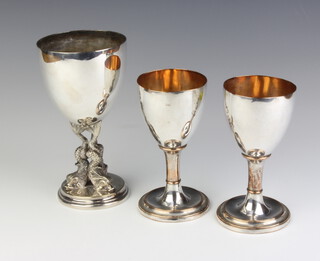 A Victorian silver plated cup with dolphin supports 17cm, a pair of Sheffield plated goblets