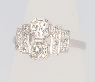 A platinum Art Deco style diamond ring with 2 brilliant cut diamonds having stepped diamond mounts, size M 1/2, total diamond weight 0.8ct