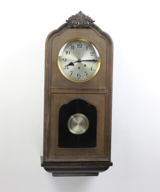A 1930's 8 day chiming wall clock with 20cm silvered dial, Arabic numerals, striking on a gong, contained in an oak case 