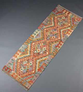 A terracotta, green and white ground Chobi Kilim runner with 4 stylised diamonds to the centre 193cm x 67cm 