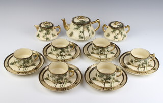 An early 20th Century Japanese Satsuma tea set comprising teapot, lidded sugar bowl, lidded jug, 6 cups, 6 saucers and 6 small plates decorated with bamboo 