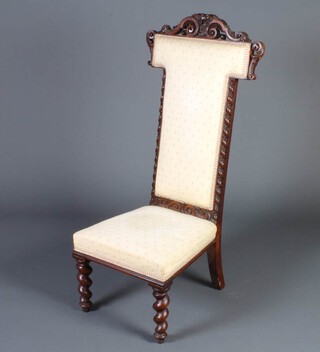 A Victorian carved and pierced oak prie-dieu chair upholstered in yellow floral material raised on spiral turned supports 