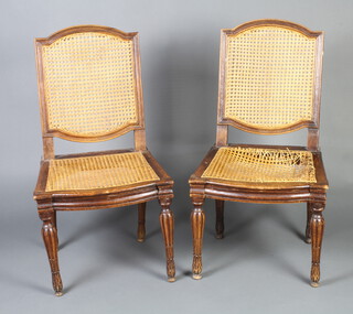 A pair of 18th Century French carved walnut chairs with woven cane seats and backs raised on turned and fluted supports (old but treated worm)