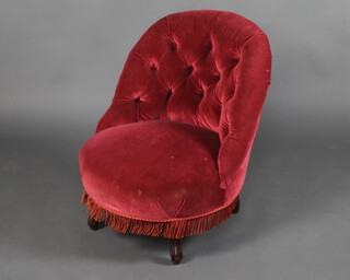 A Victorian tub back nursing chair upholstered in red buttoned material, raised on turned supports  