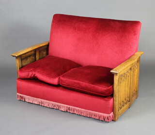 A 1930's Art Deco carved oak 2 seat settee upholstered in red material and with carved linenfold panels to the sides, 80cm h x 121cm w x 70cm d 