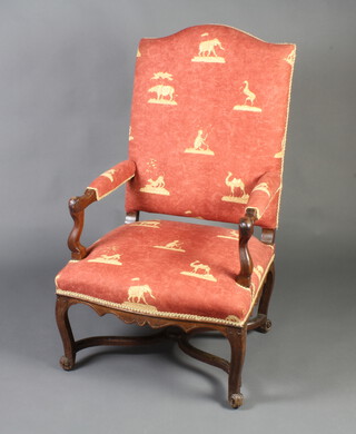 A 17th/18th Century Continental carved walnut open armchair, the seat and back upholstered in pink material with animal decoration, raised on cabriole supports with X framed stretcher 